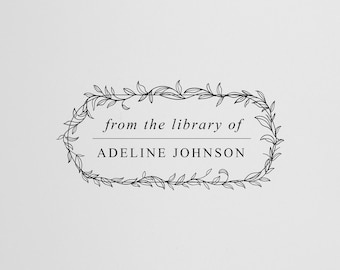May include: A black and white image of a book with a decorative stamp that reads "from the library of ADELINE JOHNSON" inside a leafy wreath.
