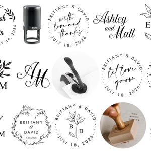 May include: An assortment of wedding stationery items, including stamps and decorative elements. Features a black self-inking stamp, circular designs with names, dates, and floral motifs, and a paper punch.