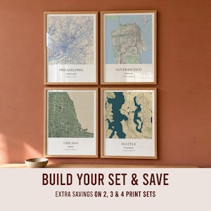 May include: Four framed wall art prints featuring map illustrations of Philadelphia, San Francisco, Chicago, and Seattle. Each print includes the city name, state, and coordinates in black text on a white background within a light wood frame.