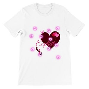 Puede incluir: Camiseta blanca con un diseño de corazón rosa y la palabra "Explicit" en letras rosas. El corazón tiene globos rosas y una mariposa.