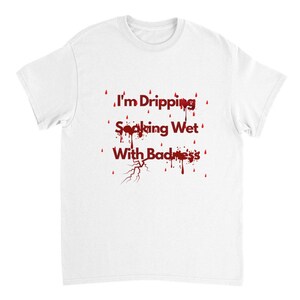 Puede incluir: Camiseta blanca con texto rojo que dice "I'm Dripping Soaking Wet With Badness" con diseños de gotas de sangre rojas alrededor del texto.