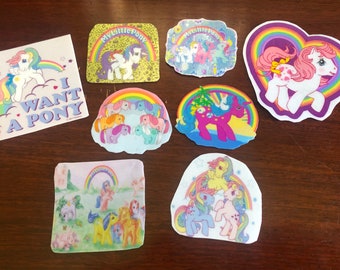 May include: A set of eight My Little Pony stickers featuring various scenes with ponies, rainbows, and the text "My Little Pony".