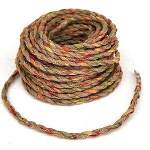 May include: A coiled length of braided cord featuring a multi-colored pattern of tan, olive green, yellow, and red threads. The cord is constructed from several strands twisted together to create a textured, rope-like appearance with a consistent weave.