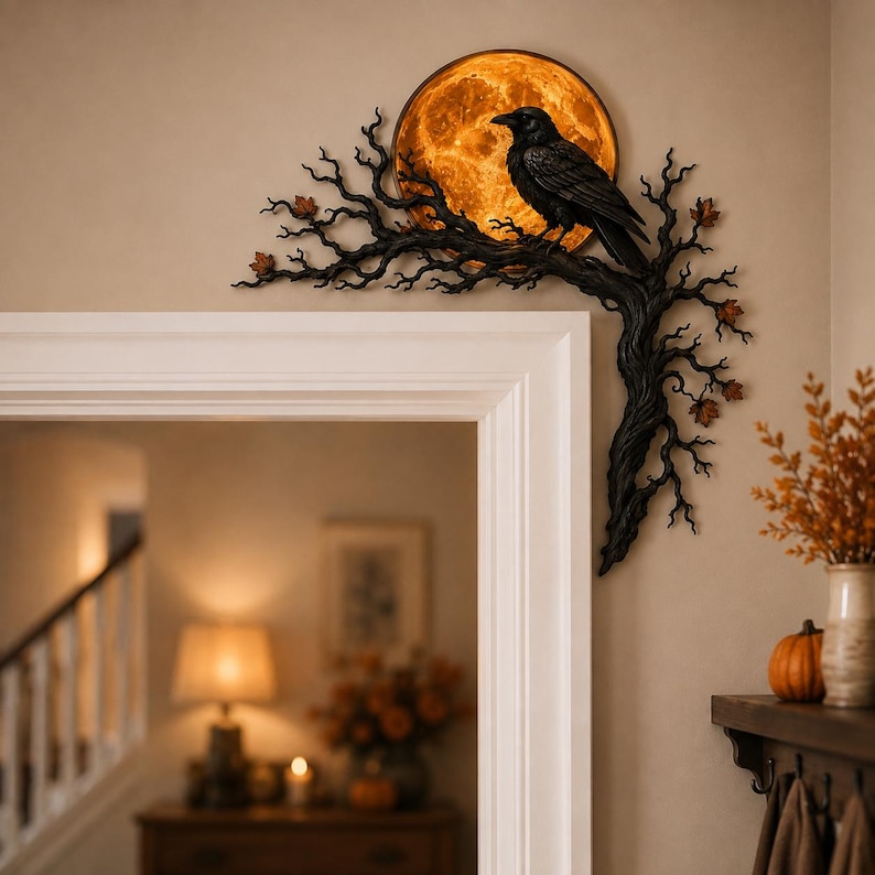 May include: A black raven perched on a dark, gnarled tree branch that extends along the corner of a door frame. Behind the bird is a circular, glowing orange moon. Small, scattered brown leaves are attached to the textured, winding branches.