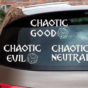 May include: A white vinyl decal applied to a car rear window featuring three distinct text and icon designs. The text reads CHAOTIC GOOD, CHAOTIC EVIL, and CHAOTIC NEUTRAL, each accompanied by a white line-art illustration of a twenty-sided die.