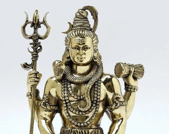 May include: A gold-colored statue of Shiva, a Hindu deity, sitting in a meditative pose. He is holding a trident in one hand and a drum in the other. He is wearing a snake around his neck and a crown on his head. He is sitting on a base with a tiger head.