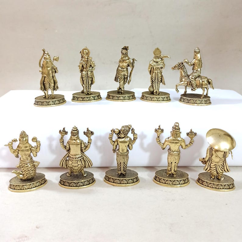 May include: Set of ten gold-colored figurines depicting Hindu deities. The figurines are standing on small circular bases and are arranged in two rows.