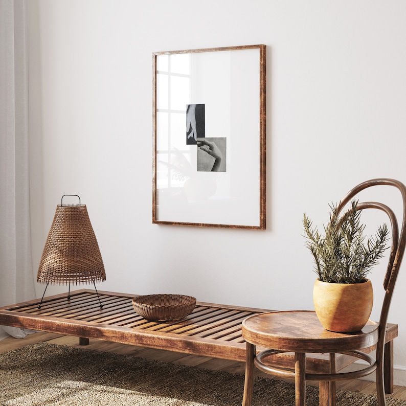 May include: A wooden bench with slatted design, a wicker lamp, a woven bowl, and a small wooden stool with a brown chair next to it. A framed black and white photo hangs on the wall behind the bench.