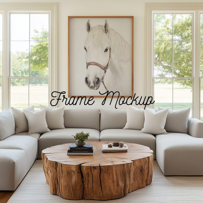 May include: A framed print of a white horse with a brown bridle hangs above a light gray sectional sofa. A large, round wooden coffee table sits on a light-colored rug. The text "Frame Mockup" is written across the image.