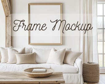 May include: A living room setting featuring a white sofa, beige cushions, and a wooden coffee table. A gold-framed picture frame mockup is on the wall, with the text "Frame Mockup". The room has a neutral colour scheme.