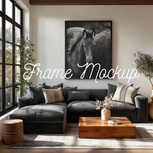 May include: A living room scene featuring a dark gray sectional sofa with several throw pillows, a wooden coffee table, and a framed black and white horse print. The text "Frame Mockup" is displayed in a cursive font.