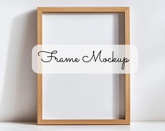 May include: A simple wooden frame mockup with a white background. The frame is on a white shelf. The text "Frame Mockup" is written in cursive on a white banner.