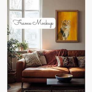 May include: A brown leather couch with a red throw blanket and pillows. A framed painting of a lion on a yellow background hangs on the wall above the couch.