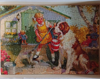 May include: A vintage jigsaw puzzle depicting a girl in a yellow dress and a St. Bernard dog holding a bucket. The puzzle is set in a garden with a house in the background.
