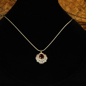 Sterling Silver Pendant set with a 10x8mm Oval Wine Red Garnet surrounded by White Topaz