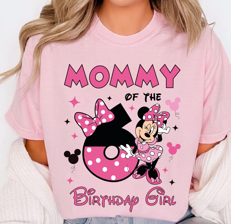 May include: Pink t-shirt with the text "MOMMY OF THE BIRTHDAY GIRL". The number 6 is in black with pink polka dots and a pink bow. Minnie Mouse is wearing a pink polka dot dress and bow.