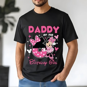 May include: Black t-shirt with a pink graphic that says "DADDY of the BIRTHDAY GIRL". The graphic includes a large number 6 with a pink bow and Minnie Mouse in a pink polka dot dress.