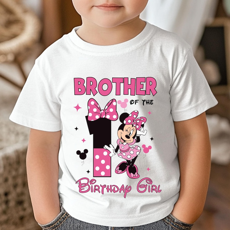 May include: White t-shirt with a pink and black graphic. The graphic includes the text "BROTHER of the BIRTHDAY GIRL" and a large number "1" with pink polka dots. Minnie Mouse is also featured in the design.