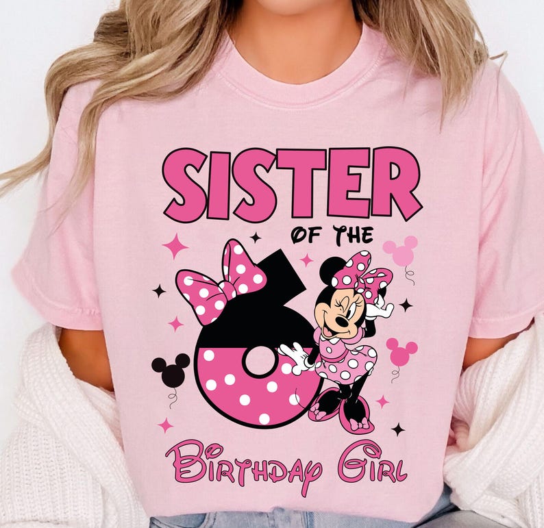 May include: Pink t-shirt with the text "SISTER OF THE BIRTHDAY GIRL". The shirt features a graphic of Minnie Mouse, a large number 6, and polka dot bows. The design is in shades of pink and black.