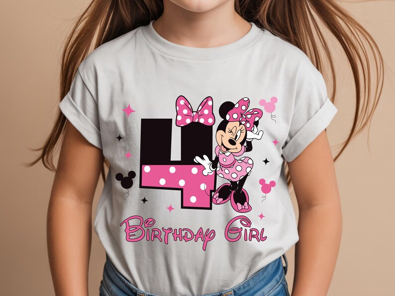 May include: A light grey t-shirt with a Minnie Mouse graphic. The design includes a pink polka dot bow, dress, and the number 4 in black with pink polka dots. The text "Birthday Girl" is in pink.