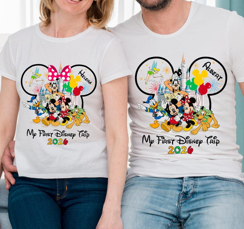 May include: White t-shirts with a Disney theme. Each shirt features a Mickey Mouse ear design with Disney characters, balloons, and the text "My First Disney Trip 2020." One shirt has "Helena" and the other "Albert".