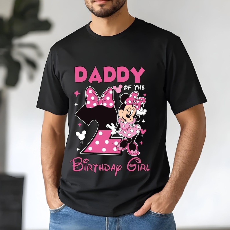 Puede incluir: Camiseta negra con un dise&ntilde;o de Minnie Mouse rosa y el texto "DADDY of the BIRTHDAY GIRL". El dise&ntilde;o incluye el n&uacute;mero 2, un lazo y estrellas. Minnie Mouse lleva un vestido de lunares.