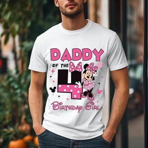 May include: White t-shirt with a pink graphic that says "DADDY of the 4 Birthday Girl". The number 4 is pink with white polka dots. Minnie Mouse is featured in a pink polka dot dress and bow.