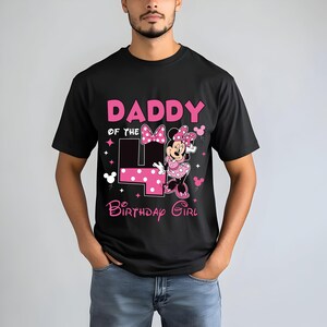 May include: Black t-shirt with a pink graphic that reads "DADDY of the 4 BIRTHDAY GIRL" featuring a Minnie Mouse design. The number 4 is in pink with white polka dots. The shirt is a short-sleeved crew neck.
