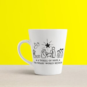 May include: White ceramic mug with a black and white illustration of the nativity scene. The text reads "A thrill of hope, the weary world rejoices."