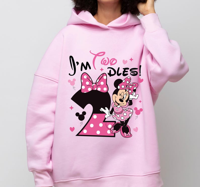 May include: A light pink hooded sweatshirt featuring a Minnie Mouse graphic. The design includes the text "I'm Two DLES!" with a large number 2, a polka dot bow, and Minnie Mouse. The sweatshirt is a comfortable, casual style.