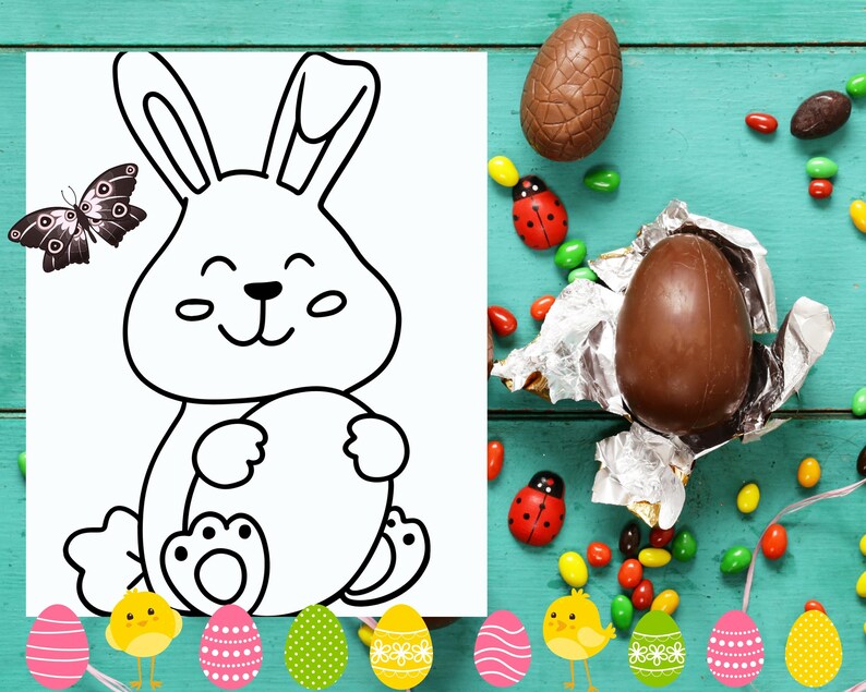 May include: A black and white line drawing of a bunny rabbit holding an egg. The bunny is smiling and has big eyes. The image is on a white sheet of paper with a blue wooden background. There are chocolate eggs, candy, and ladybugs scattered around the paper.
