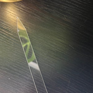 May include: A clear plastic tool with a pointed tip and a rounded end. It is a plant propagation tool used for starting new plants from cuttings.