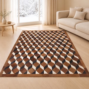 May include: A rectangular area rug featuring a repeating geometric pattern of three-dimensional cubes in shades of brown, black, and white. The rug is constructed from individual leather patches arranged to create a visual depth effect.