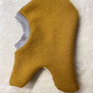 May include: A mustard yellow fleece balaclava with a gray ribbed knit trim around the neck opening.