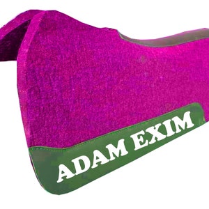 May include: A pink saddle pad with a green border and the text "ADAM EXIM" in white.