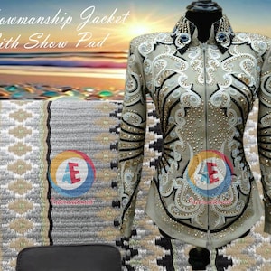 Könnte beinhalten: Eine beige Showmanship-Jacke mit schwarzen und weißen Stickereien und Strasssteinen. Die Jacke hat einen Reißverschluss und einen Stehkragen. Die Jacke wird mit einem beige-weißen Showpad mit geometrischem Muster kombiniert.