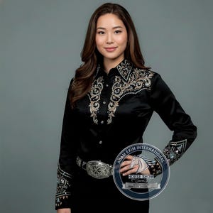 May include: A black long-sleeved shirt with detailed embroidery and embellishments on the collar, cuffs, and front. The shirt features a button-down design and is worn with a silver belt. The image includes a logo that says "Horse Show".