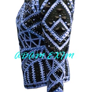 Pode incluir: Uma camisa de exibi&ccedil;&atilde;o preta e azul claro com um padr&atilde;o geom&eacute;trico e detalhes cravejados.