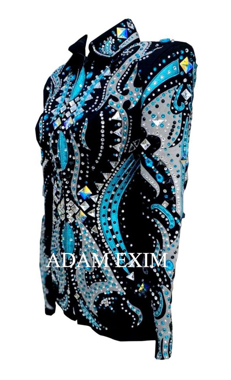 May include: A black show shirt with a turquoise and silver design. The shirt is covered in rhinestones and has the text "ADAM EXIM" on the front.