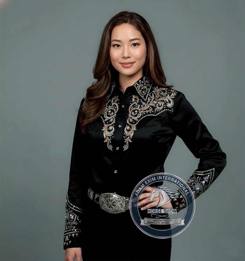 May include: A black long-sleeved shirt with detailed embroidery and embellishments on the collar, cuffs, and front. The shirt features a button-down design and is worn with a silver belt. The image includes a logo that says "Horse Show".