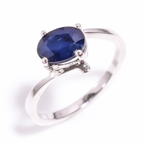 Könnte beinhalten: Ein silberner Ring mit einem großen, ovalen blauen Saphir-Edelstein.