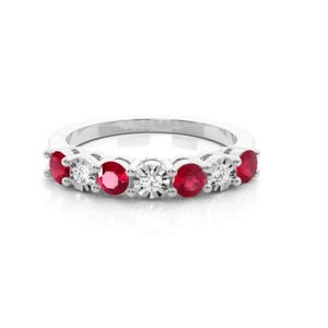 May include: A silver band ring with alternating red rubies and clear diamonds.