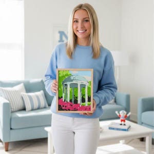 UNC Chapel Hill Tar Heel student holding the completed Old Well Painting from the DIY Paint by Number kit
