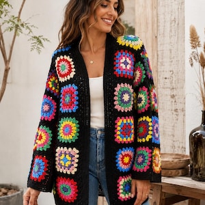 May include: A black crochet cardigan with colorful square patterns. The open-front sweater features vibrant squares in red, yellow, blue, green, and pink. The cardigan is a stylish, handmade garment.