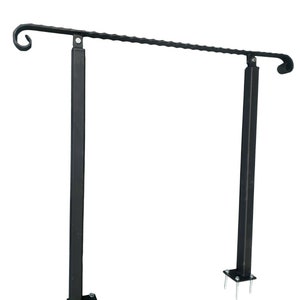 May include: Black metal handrail with a decorative scroll design. The handrail is supported by two vertical posts with square bases. Each post has four screws securing it to the base.