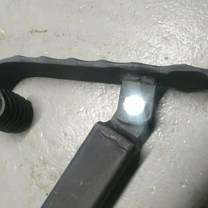 May include: Close-up of a black metal handrail with a decorative scroll design. The handrail is made of wrought iron and has a textured finish.