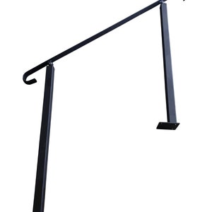 May include: Black metal handrail with two vertical supports and a curved top. The handrail is angled upwards.