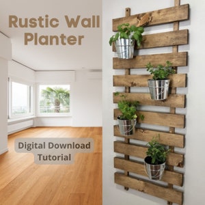 Op de afbeelding: Een rustieke wandplanter van gebeitst hout, met vier gegalvaniseerde metalen emmers met groene planten. De planter is aan een witte muur bevestigd. De tekst op de afbeelding luidt "Rustic Wall Planter" en "Digital Download Tutorial".