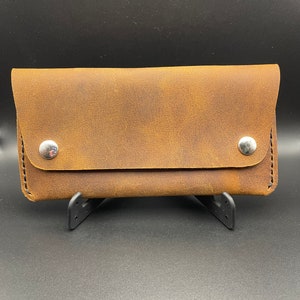 Cartera larga de piel de camionero. Tiene capacidad para mucho dinero en efectivo y tarjetas. Con cierre a presión.