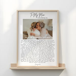 Peut inclure: Impression encadrée avec une photo d'une mère et de sa fille s'embrassant, avec le texte "To My Mum On My Wedding Day" et "Your Photo Here". L'impression est dans un cadre en bois clair et repose sur une étagère en bois.